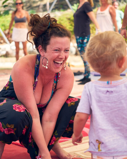 Lady smiling and playing at a yoga festival