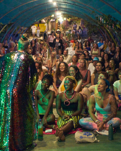 Retreat host on stage speaking to her attendees for her wellness festival