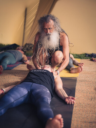 Yoga teacher hands on adjustment at a yoga festival