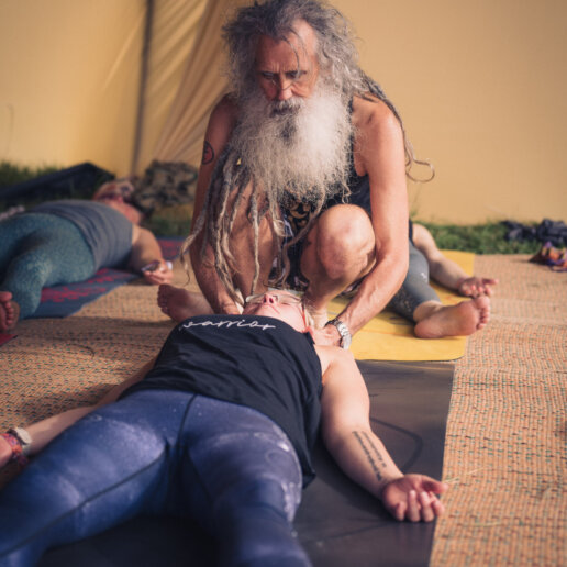 Yoga teacher hands on adjustment at a yoga festival