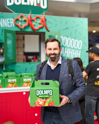 Man posing holding a gift from a pop up event