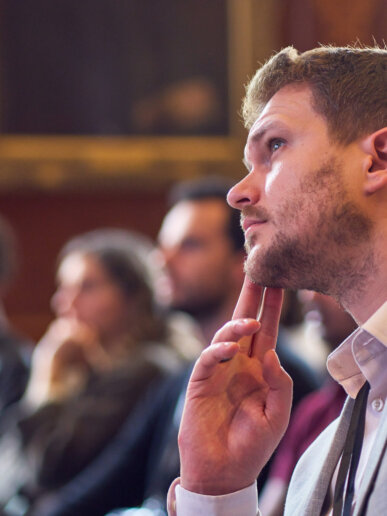 Candid moment for someone listening to a speaker on stage and deep in thought