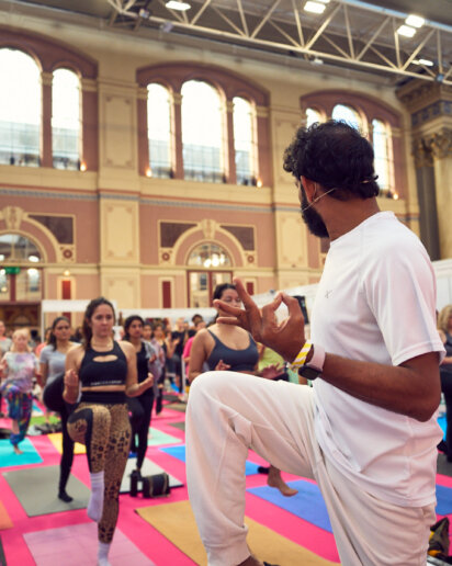 Yoga instructor leading session on stage at UK wellness festival